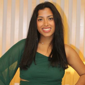 Riddhi Bansal poses for photo with warmly lit background.