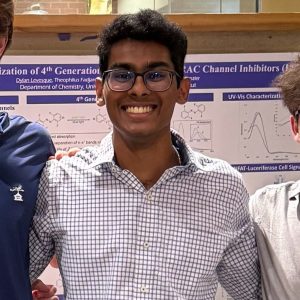 Chevintha Edirisinghe poses for photo with poster presentation in background.